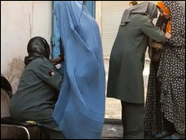 petugas pemilhan memeriksa warga yang akan mencoblos