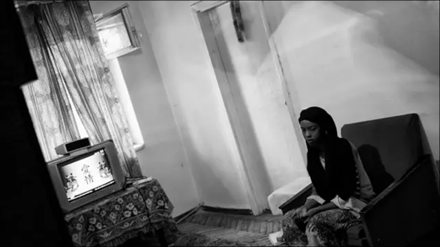 Девушка-африканка сидит на кресле в комнате