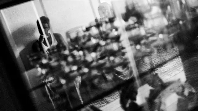 Отражение сидящего на стуле мужчины 