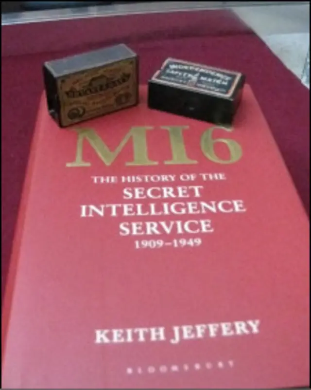 Фотокамера в виде спичечного коробка на фоне книги