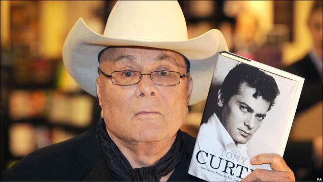 Tony Cutis con una copia de su autobiografía.