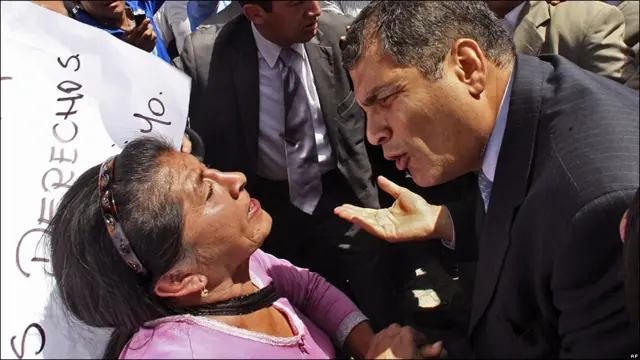 El presidente Rafael Correa habla con una mujer.