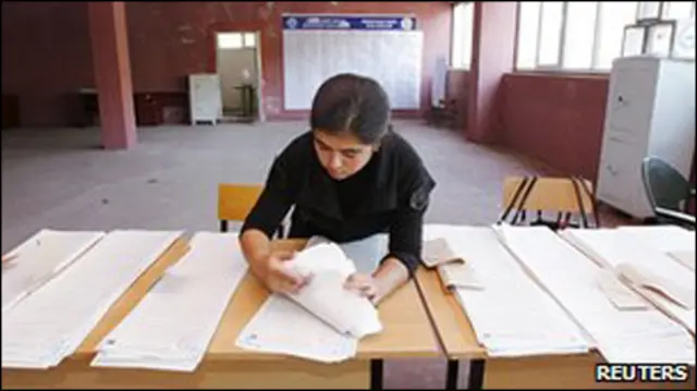 امرأة تنظم أوراقا انتخابية في مدينة أوش