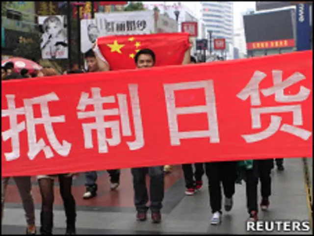 手持“抵制日货”横幅的示威者走过四川成都春熙路(16/10/2010)