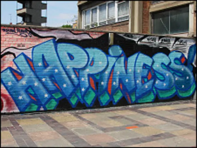 Надпись "счастье" (на английском языке) на стене в Лондоне