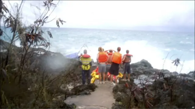 Warga setempat mencoba menolong dengan melemparkan tali tambang dan pelampung dari pinggir laut. 