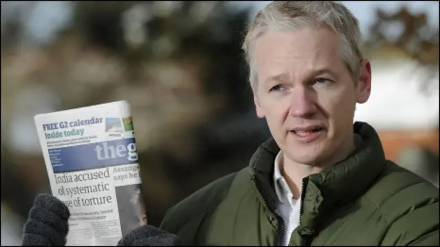 جوليان اسانج يحمل صحيفة الجارديان