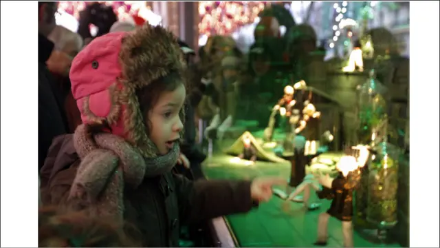 یوه ماشومه په پاریس کې د کریسمس لپاره جوړې شوې مجسمې ګوري