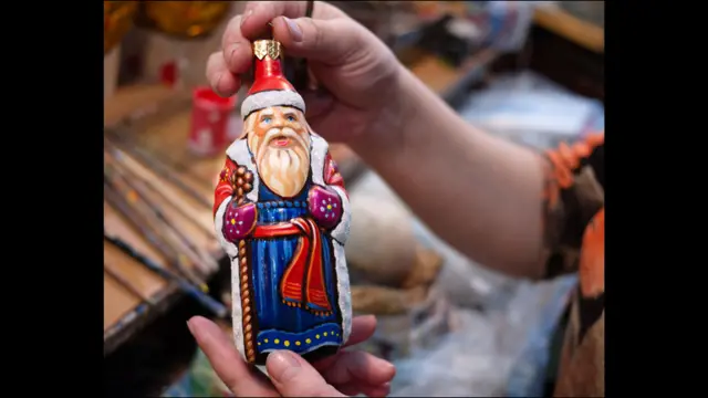 Художница держит фигурку Деда Мороза