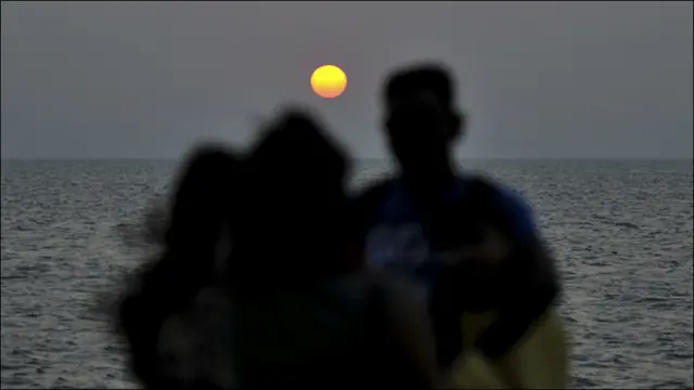 دوه سیلانیان په ممبۍ کې د ۲۰۱۰ کال د وروستۍ ورځې د لمر لوېدو ننداره کوي.