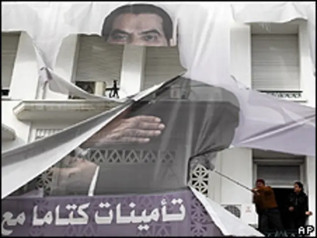 Moradores de Túnis tentam arrancar retrato de ex-presidente Ben Ali (foto: AP)