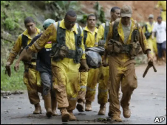 Equipe de resgate retira corpo de vítima de deslizamento