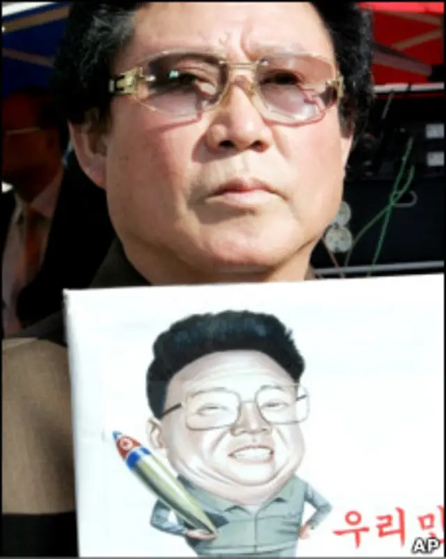 Участник митнга в Южной Корее с карикатурой на Ким Чен Ира