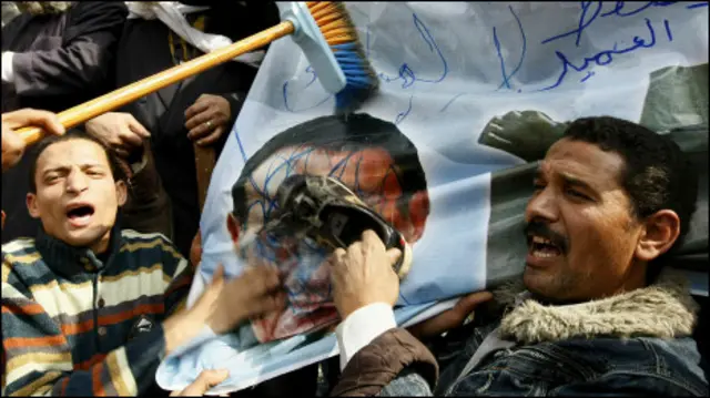 Người biểu tình vẽ bẩn và đập giầy vào áp phích có hình ông Mubarak