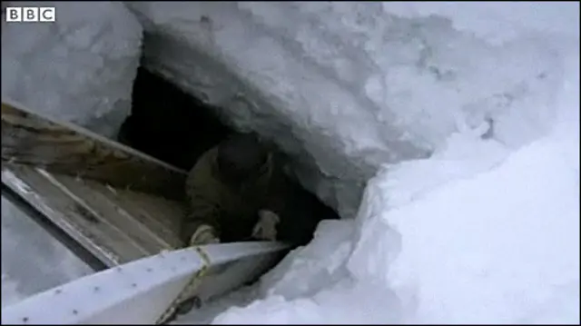 Esquimó desce a caverna de gelo formada no mar Ártico