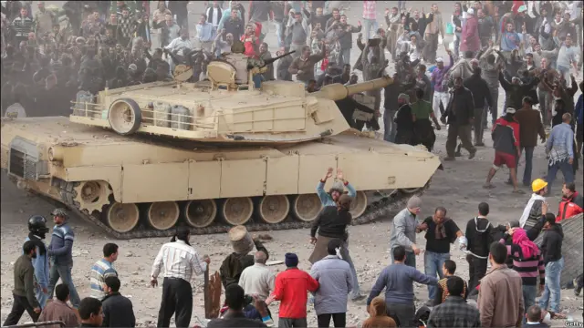 Berbeda dengan insiden serupa hari Rabu, tentara Mesir terlihat berupaya meredam bentrokan, termasuk dengan membuat tabir asap dari kendaraan lapis baja mereka untuk massa oposisi. 