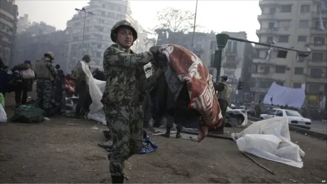 Sebagian tentara membantu demonstran untuk membersihkan tenda dan selimut yang mereka pakai dalam aksi mereka selama beberapa hari.