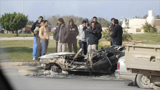 مجموعة من الشباب تجمعت حول مركبة محترقة في بنغازي