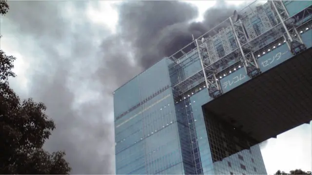 په توکیو کې له یوې زیانمنې شوې ودانۍ لوګي پورته کېږي . 