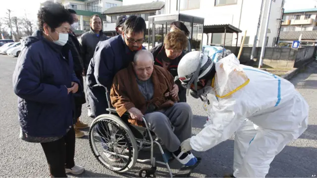 Orang tua di kursi roda menjalani pemeriksaan Di Fukushima