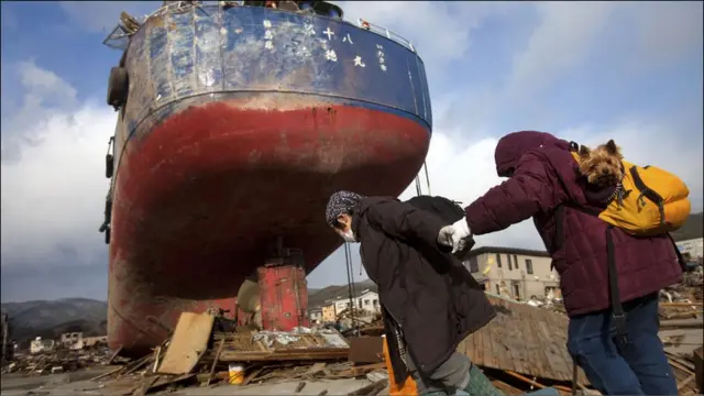 幸存者回到被地震和海啸摧毁的家园，察看能否重建。