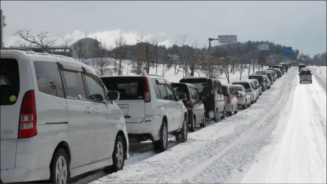 缺乏汽油和食品导致局势更糟，这是一个加油站前排长队等加油的车辆。