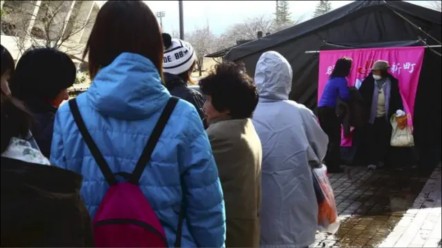 供水也成问题。这些从福岛附近撤离的人们正在一个临时浴室前排队等洗澡。