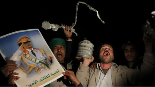 Massa pendukung Gaddafi menunjukkan sisa-sisa misil yang ditembakkan pasukan Barat