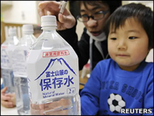 东京一家幼儿园内一名小孩拿着刚分发的应急瓶装水（24/3/2011）