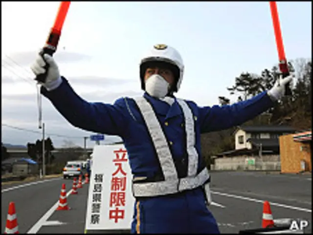 一名日本警员在福岛县岩城市的30公里自愿撤离区边界执勤(25/3/2011)
