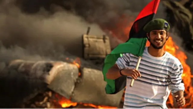 Pemberontak di Libia melewati tank yang terbakar karena pemboman koalisi