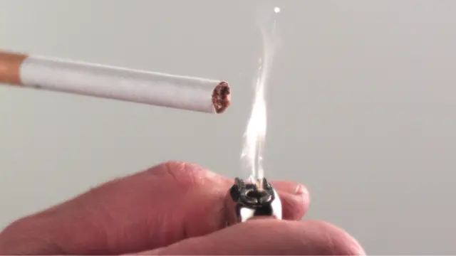 Мужчина прикуривает сигарету