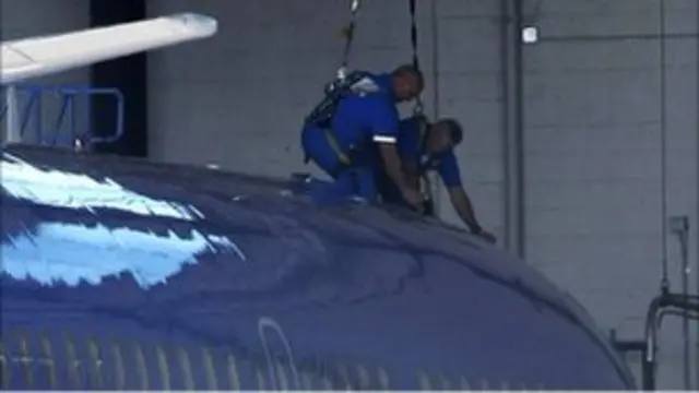 Petugas mengecek lubang di atap pesawat