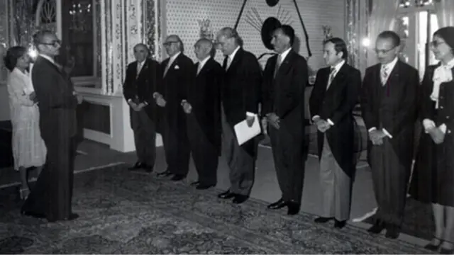 مهر 1355؛ از چپ هویدا، شریف امامی عبدالله ریاضی، اقبال مدیر عامل شرکت نفت، جمشید آموزگار و هوشنگ انصاری از رهبران حزب رستاخیز، همراه با دو عضو بنیاد اشرف پهلوی در دیدار با محمد‌رضا پهلوی و خواهرش اشرف