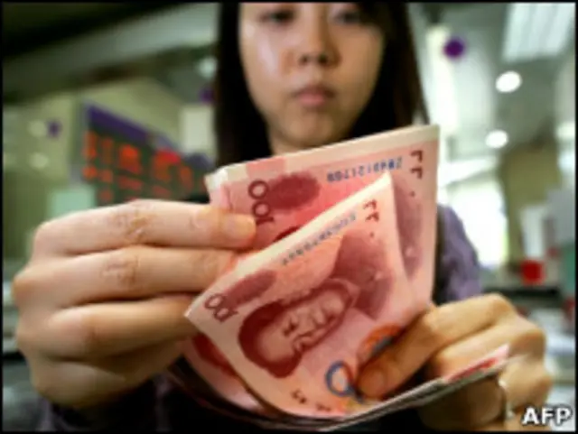 Funcionária de banco conta notas de moeda chinesa em Pequim