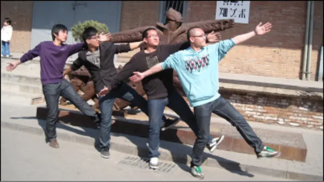 Jovens chineses imitam estátua em centro cultural em Pequim