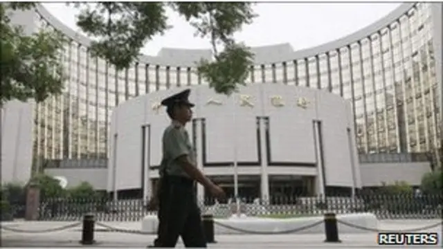 Penjaga berjalan melewati Bank Rakyat Cina