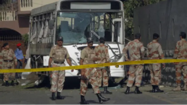 Pasukan keamanan Pakistan berjaga di sekitar bis yang diserang bom di Karachi.