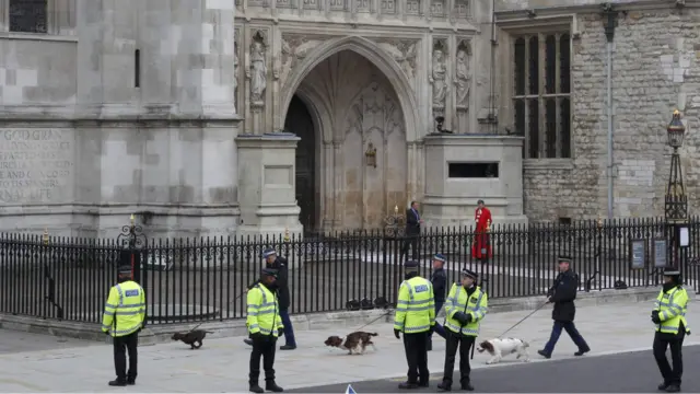 Polisi, petugas kebersihan dan rohaniwan melakukan pengecekan akhir terhadap persiapan di luar dan dalam Westminster Abbey.