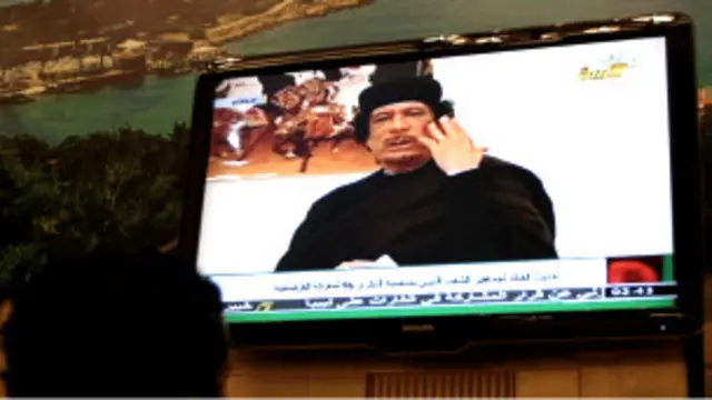 Seorang warga Libia menyaksikan Gaddafi di televisi