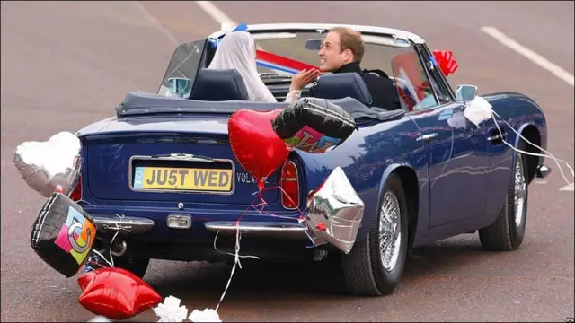 Молодята залишають Букінгемський палац в прикрашеному батьковому авті Астон Мартін.