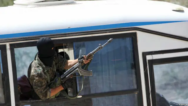 新疆喀什举行的上合组织“天山二号”反恐演习上“恐怖分子”在“劫持”的客车上鸣枪（新华社图片6/5/2011）