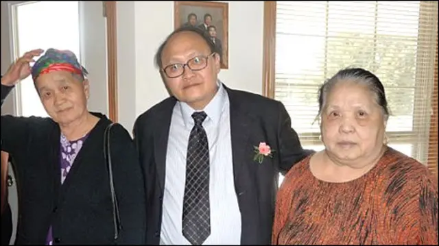 Ông Chu Vang (giữa) thăm một gia đình người Hmong ở Wisconsin, Hoa Kỳ