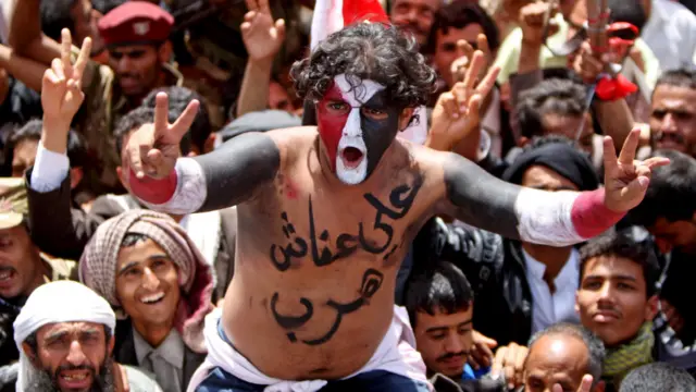 Demonstran mencat wajah dengan warna bendera Yaman sebagai ungkapan suka cita.