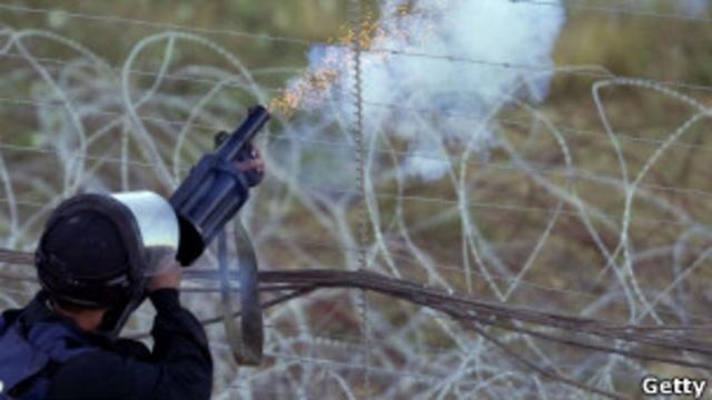 Израильский солдат, стреляющий шашками со слезоточивым газом