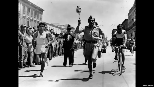 عداء إيطالي يحمل الشعلة عبر شوارع باري في طريقها إلى لندن.