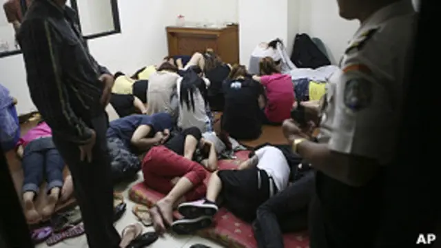 印尼雅加达移民官员展示被警方拘捕的台陆诈骗嫌疑人（10/6/2011）