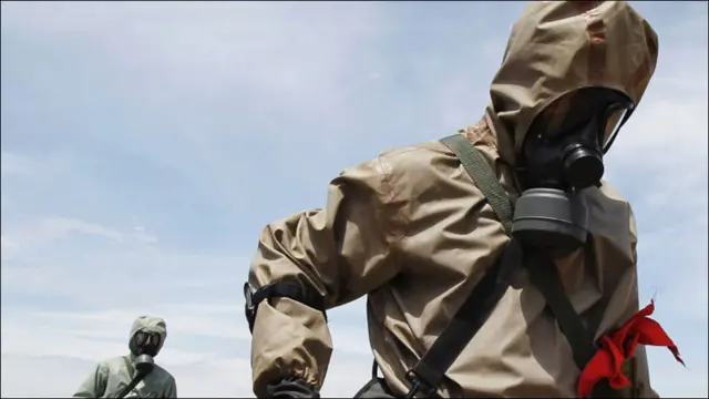 Binh lính mang trang bị bảo hộ dò tìm mìn chưa nổ và và dấu vết chất Da cam. Chất Da cam (Agent Orange) là chất diệt lá mà quân đội Mỹ rải xuống các cánh rừng Việt Nam trong cuộc chiến nhằm truy tìm bộ đội Bắc Việt.