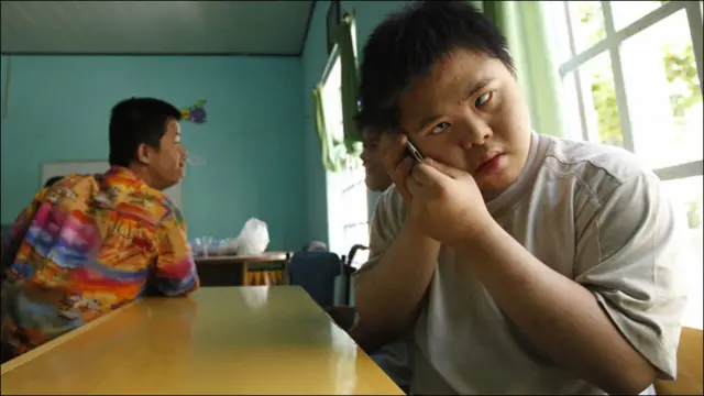 Nạn nhân Trần Văn Bảo (18 tuổi) đang cầm mảnh giấy giả làm điện thoại di động. Chùm ảnh do Huy Khâm của Reuters chụp.