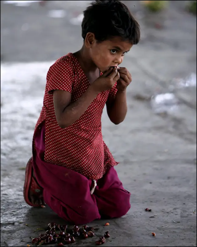 5-річна дівчинка їсть зіпсовані вишні на одному з індійських базарів. 